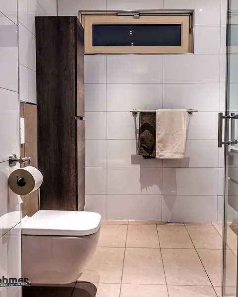 Door Böhmer gerenoveerde badkamer met hangend toilet en glazen douchedeur