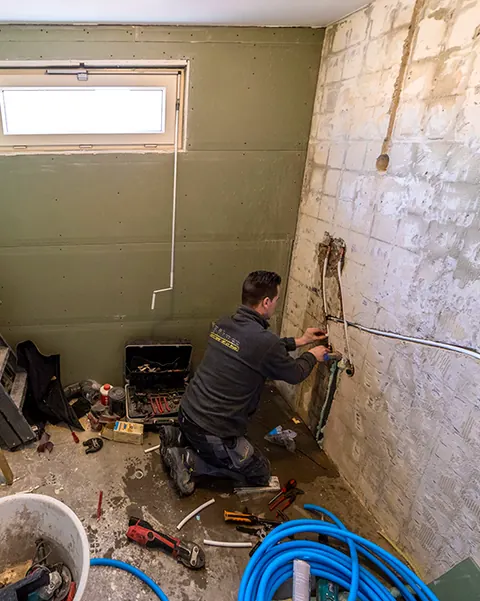 Vakman aan het werk in een badkamer die wordt gerenoveerd