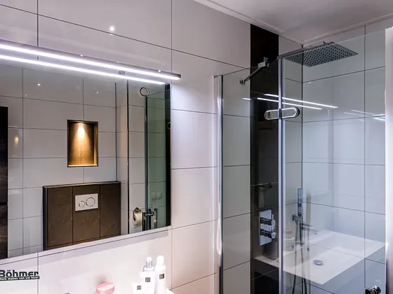 Gerenoveerde badkamer met spiegelwand en inloopdouche